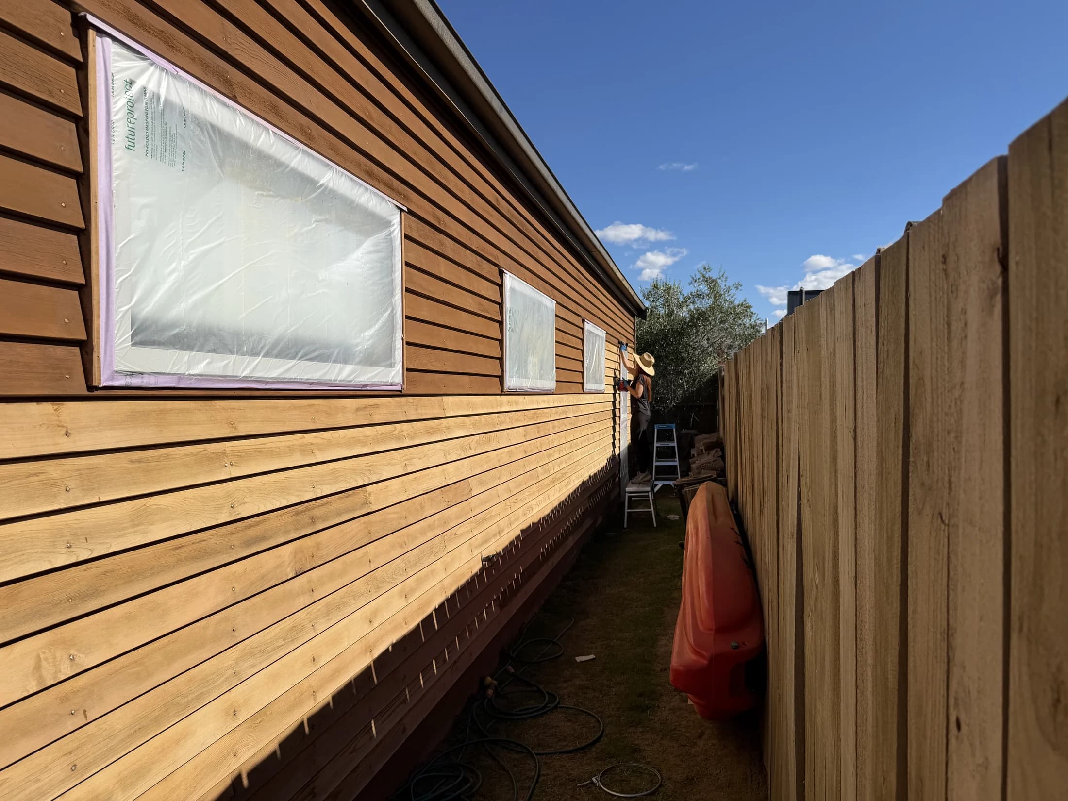 Staining cedar weatherboards in progress in Northlake, Wanaka