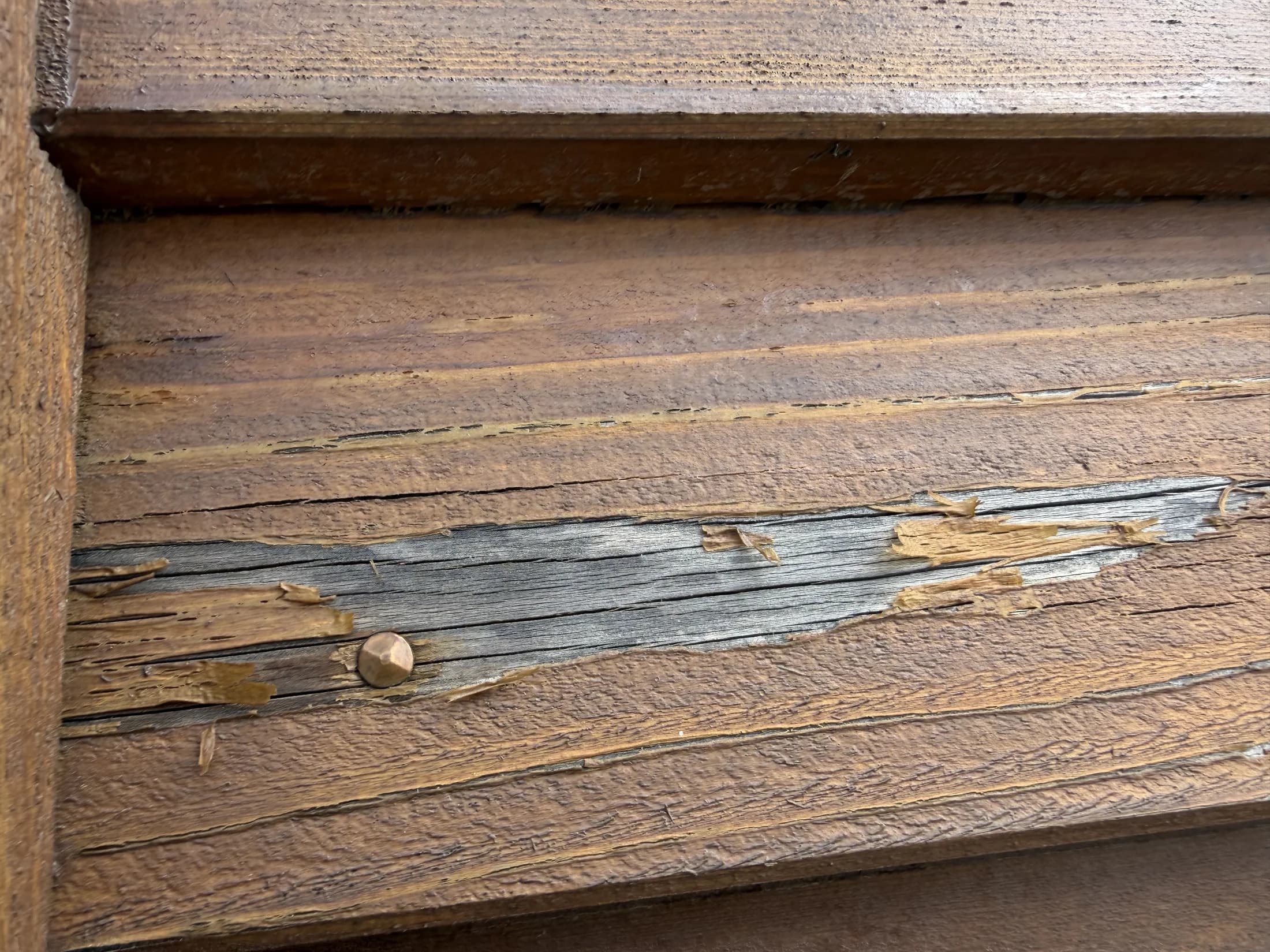 Close up of peeling cedar stain before restoration in Northlake, Wanaka
