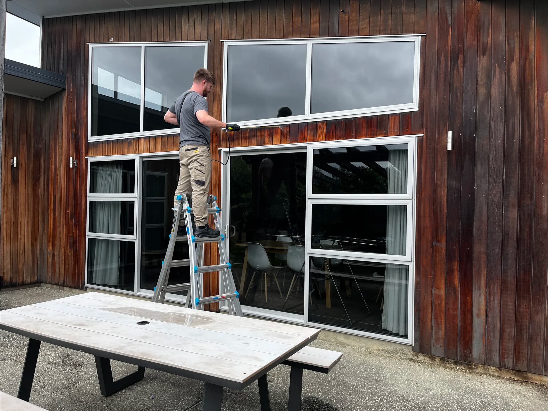 Masking windows during cedar exterior preparation in Albert Town