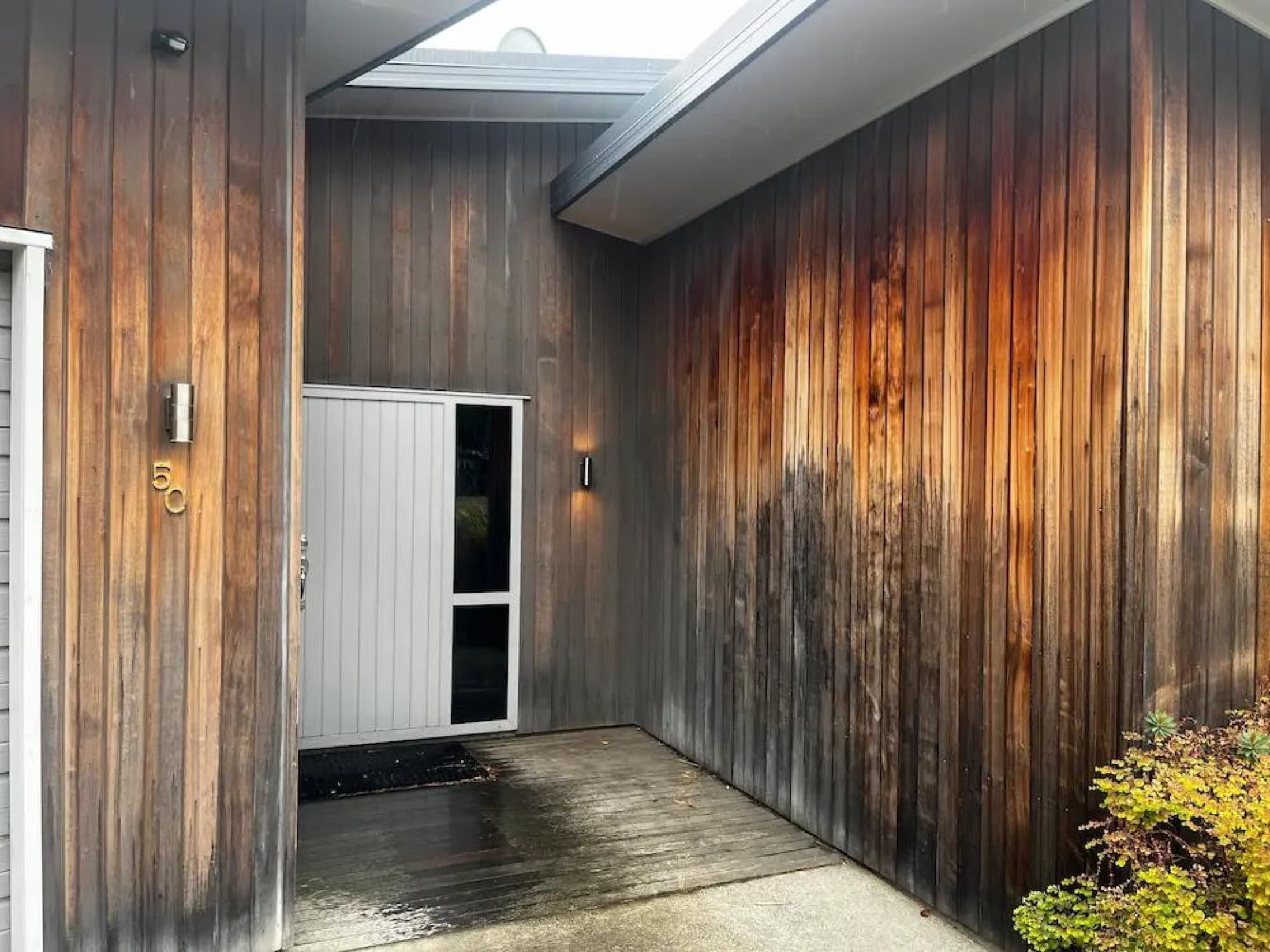 Weathered cedar cladding at the entry before staining in Albert Town